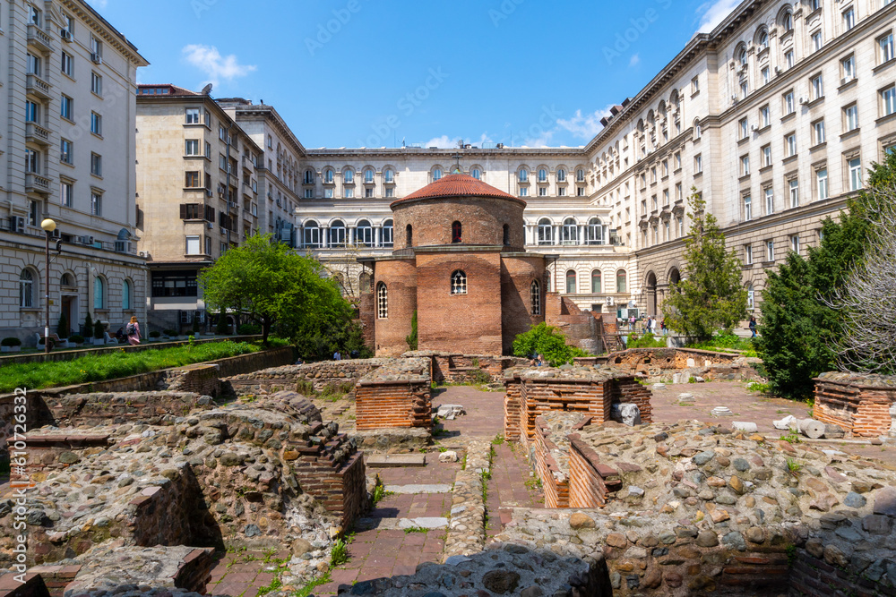 Church of Saint George in the city of Sofia, surrounded by Soviet-style buildings, on a sunny day.