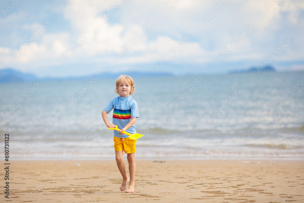 Kids play on tropical beach. Sand and water toy.