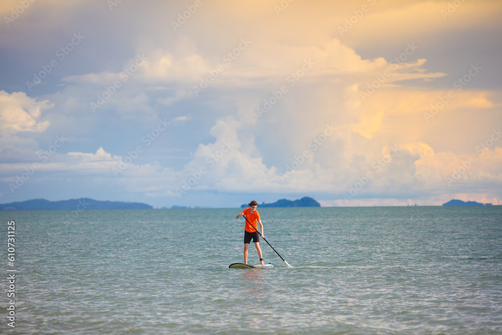 Naklejka premium Man on stand up paddle. Water and beach sport