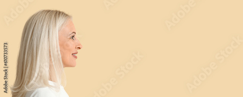 Mature blonde woman on beig...