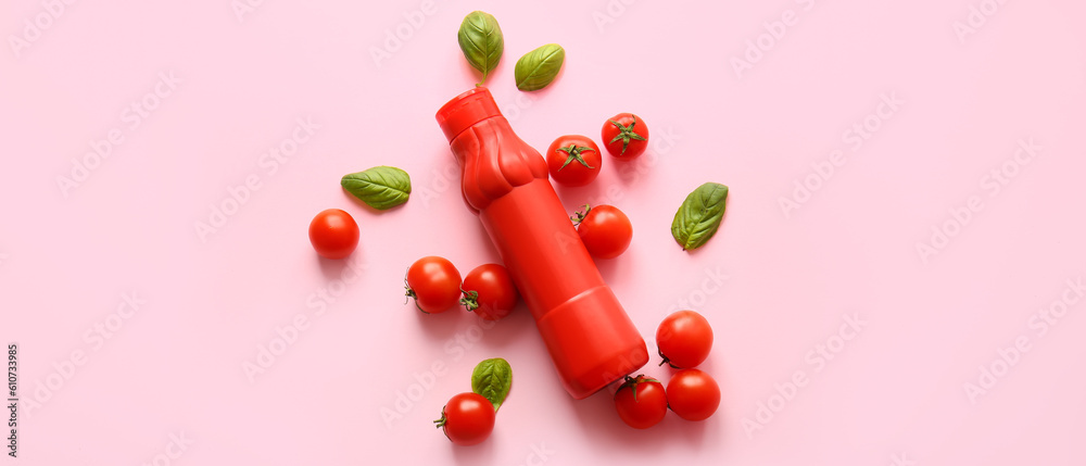 Bottle of ketchup, basil and tomatoes on pink background, top view Bottle of ketchup, basil and tomatoes on pink background, top view