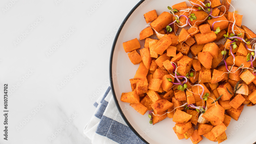 Baked sweet potato slices in a plate on the table. Healthy eating. Vegan dish. Copy space Baked sweet potato slices in a plate on the table. Healthy eating. Vegan dish. Copy space