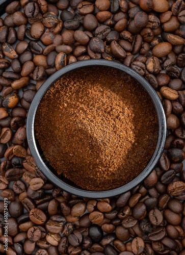 Ground coffee in a ceramic bowl with a background of coffee beans