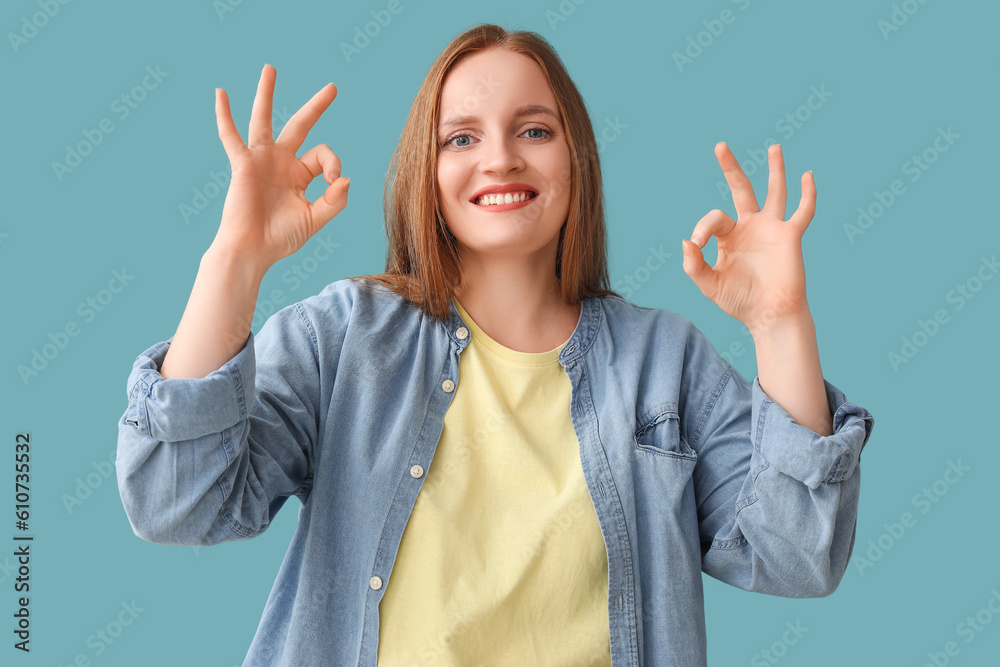 Beautiful redhead woman showing OK on blue background Beautiful redhead woman showing OK on blue background