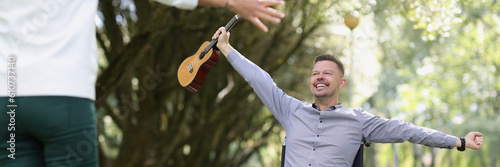 Disabled man playing on ukulele in park