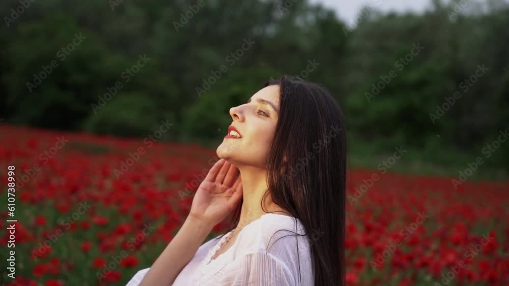 A beautiful woman in a short white dress in a poppy field, among beautiful scarlet flowers, smiles and poses in the wind.Nature concept A beautiful woman in a short white dress in a poppy field, among beautiful scarlet flowers, smiles and poses in the wind.Nature concept