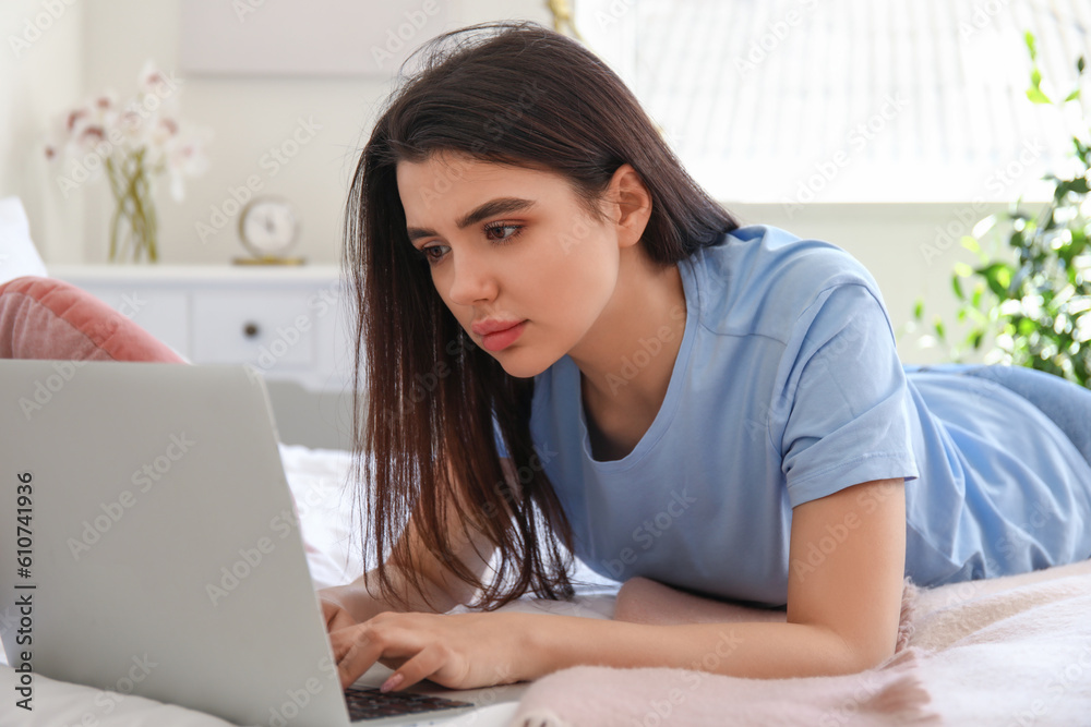Female freelancer working with laptop in bedroom Female freelancer working with laptop in bedroom