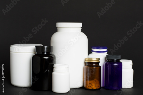Plastic bottles for vitamins on color background