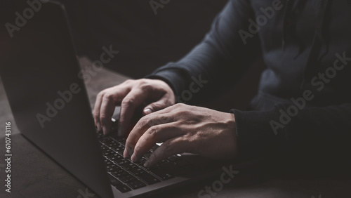Hacker hand typing on laptop computer keyboard when trying to launch cyber attack to victim security protection. Hacking, Identity theft, phishing, virus and cyber threat concept.
