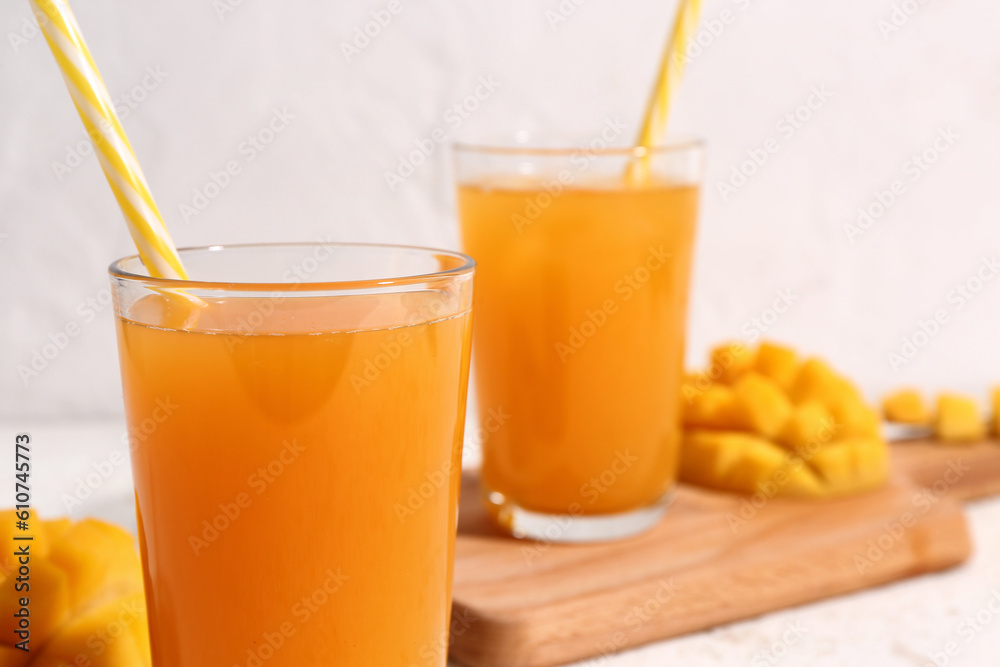 Fototapeta premium Glasses of fresh mango smoothie on light background, closeup
