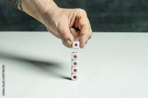 A hand placing a dice on a smooth