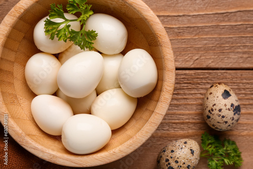 Bowl of boiled quail eggs on wooden background