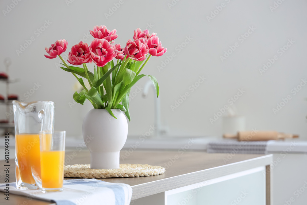 Vase with tulips on table in light kitchen Vase with tulips on table in light kitchen