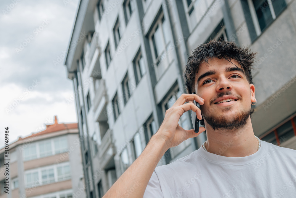 young man on the street talking on mobile phone or smartphone