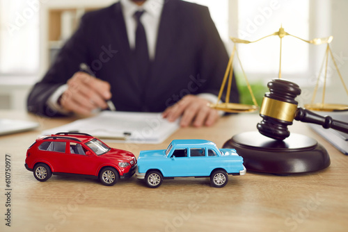 Quadro su tela Close up of two toy model cars on background of judge who is conducting lawsuit in car accident