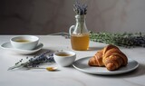  a croissant on a plate next to a cup of tea and a vase with lavender on a marble table top with lavenders.  generative ai