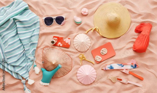  a beach towel, hat, sunglasses, and other items are laid out on the sand on a beach towel with a blue and white striped top. generative ai