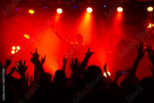 Concierto en vivo de Rock Metal, con publico enardecido, vibrando al son de la musica extrema. En un escenario con juego de luces, humo y sombras