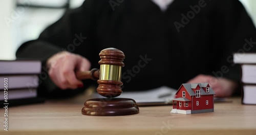 Judge knocks judge wooden gavel on background of house. Seizure of debtor property photo