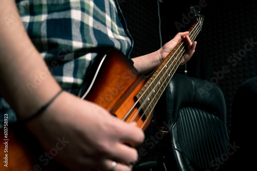 rock performer with electric guitar in recording studio recording playing own track creating song musical instrument strings close-up