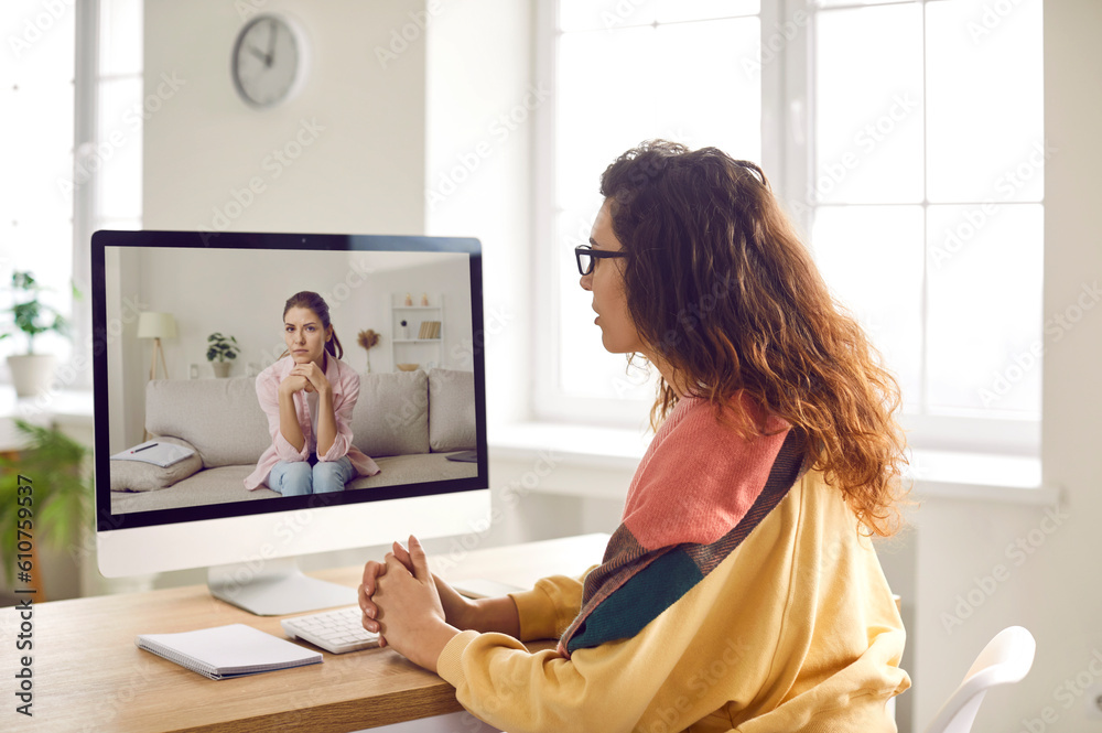 Professional therapist or psychologist gives video consultation via webcam camera conference meeting on computer and helps young woman patient understand herself. Online therapy, psychotherapy concept