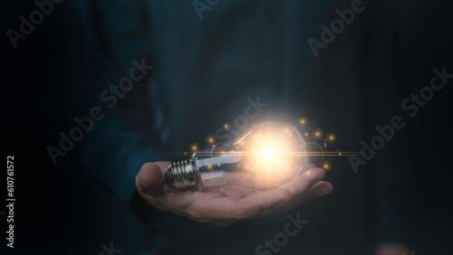 hand and light bulb. idea concept with innovation and inspiration, Innovative idea in businessman, illuminated light bulb. idea, innovation, thinking, and inspiration for business digital data idea.