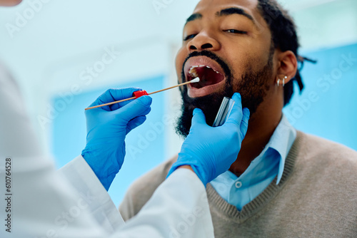 African American man during throat examination at doctor's office. photo