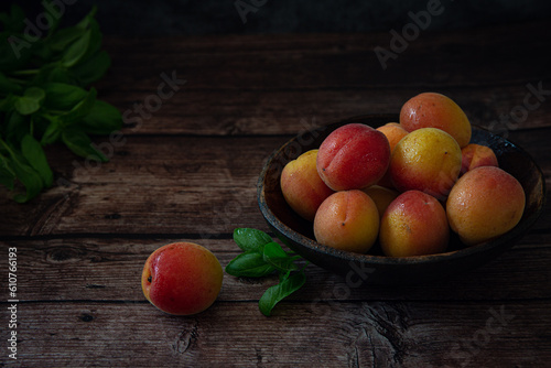 Fresh orange apricots on wooden table with dark background