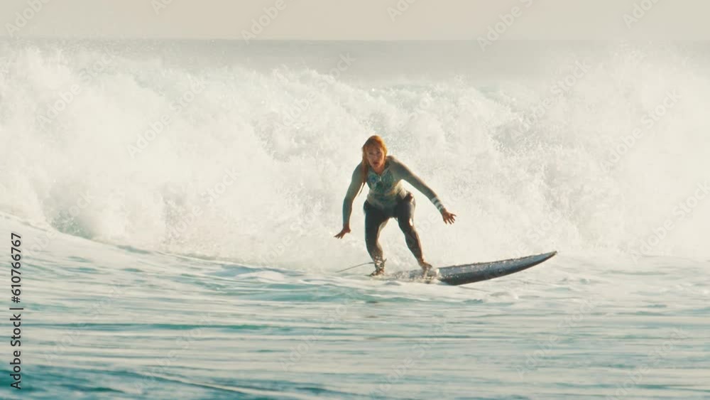 Beginner adult female surfer surfs the wave in the Maldives at sunset Beginner adult female surfer surfs the wave in the Maldives at sunset