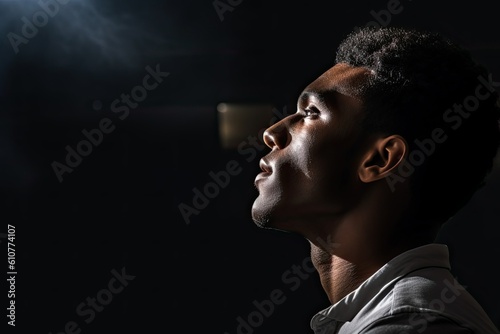 portrait of a young black man in profile on a black background