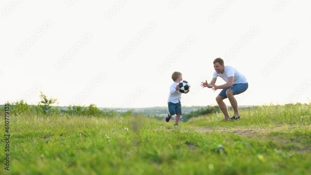 Funny cunning little boy runs away from a dad with a ball Funny cunning little boy runs away from a dad with a ball