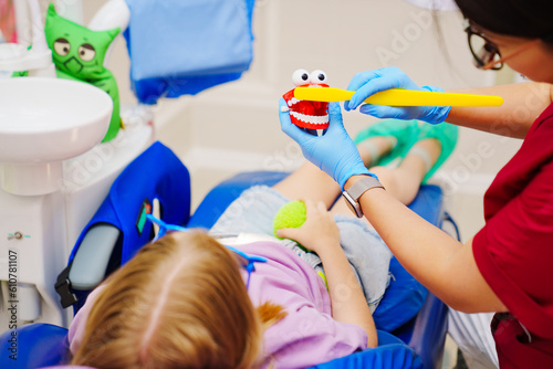 Cheerful pediatric dentist with a patient. training in proper brushing