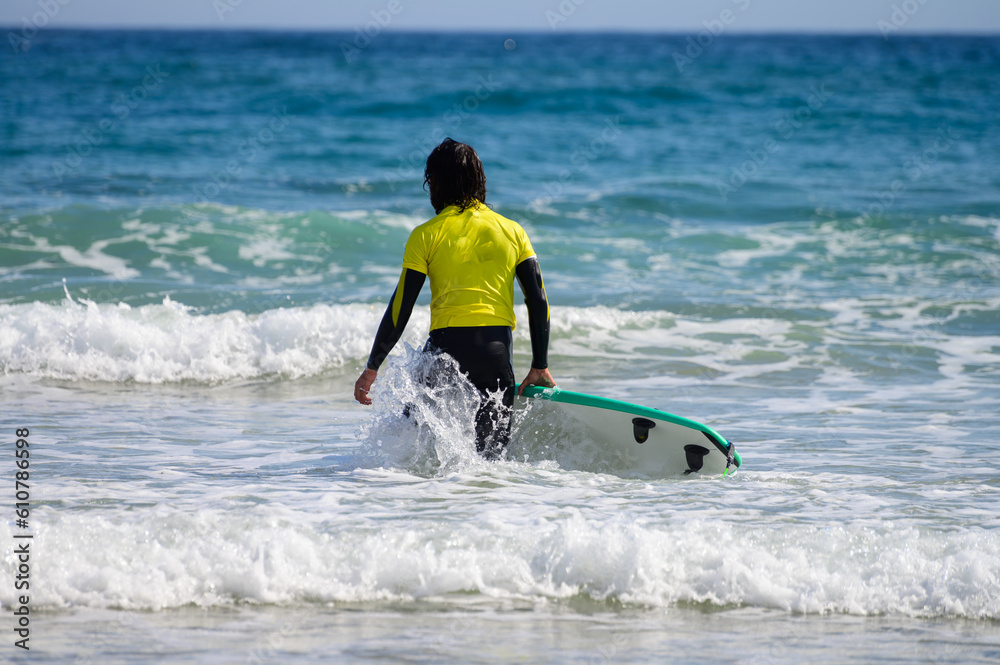 Young surfers train on Playa de Palombina Las Camaras in Celorio, Green coast of Asturias, North Spain with sandy beaches, cliffs, hidden caves, green fields and mountains Young surfers train on Playa de Palombina Las Camaras in Celorio, Green coast of Asturias, North Spain with sandy beaches, cliffs, hidden caves, green fields and mountains