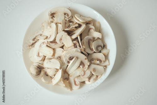 Fresh champignons mushroom in a white bowl on table 