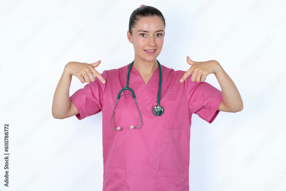 Pick me! Confident, self-assured and charismatic young caucasian doctor woman wearing pink uniform over white background promoting oneself as wanting role smiling broadly and pointing at body. Pick me! Confident, self-assured and charismatic young caucasian doctor woman wearing pink uniform over white background promoting oneself as wanting role smiling broadly and pointing at body.