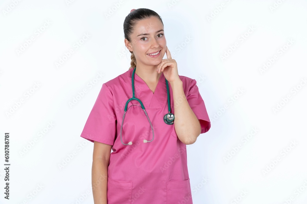 Carefree successful young caucasian doctor woman wearing pink uniform