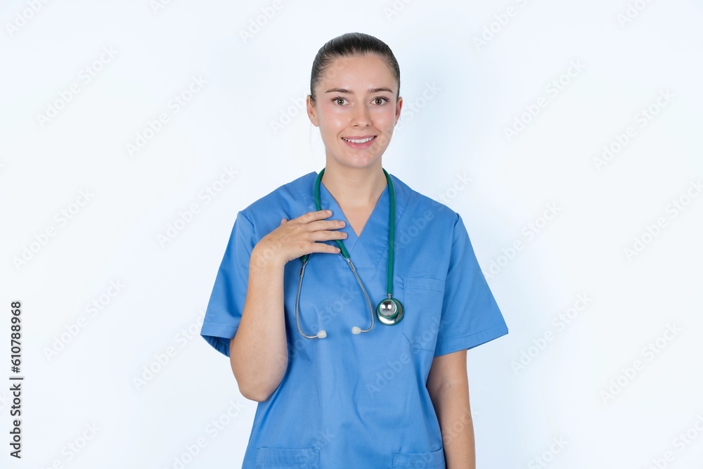 young caucasian doctor woman wearing medical uniform over white background smiles toothily cannot believe eyes expresses good emotions and surprisement young caucasian doctor woman wearing medical uniform over white background smiles toothily cannot believe eyes expresses good emotions and surprisement