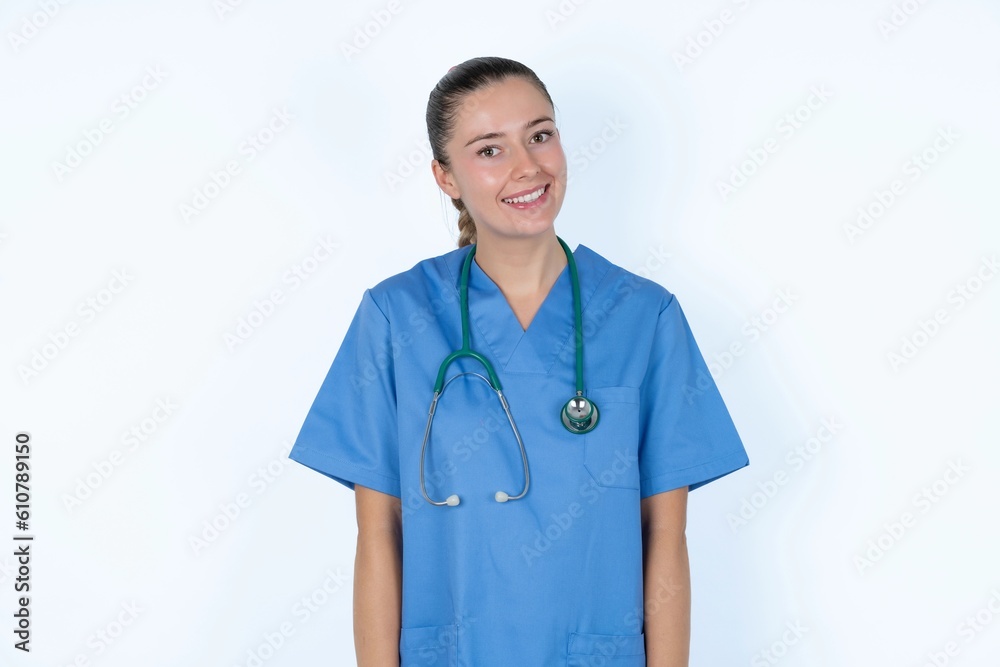 Positive young caucasian doctor woman wearing medical uniform over white background with overjoyed expression closes eyes and laughs shows white perfect teeth Positive young caucasian doctor woman wearing medical uniform over white background with overjoyed expression closes eyes and laughs shows white perfect teeth
