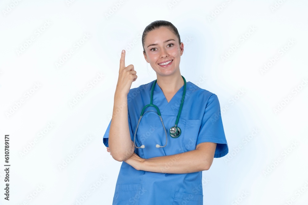 young caucasian doctor woman wearing medical uniform over white background smiling and looking friendly, showing number one or first with hand forward, counting down young caucasian doctor woman wearing medical uniform over white background smiling and looking friendly, showing number one or first with hand forward, counting down