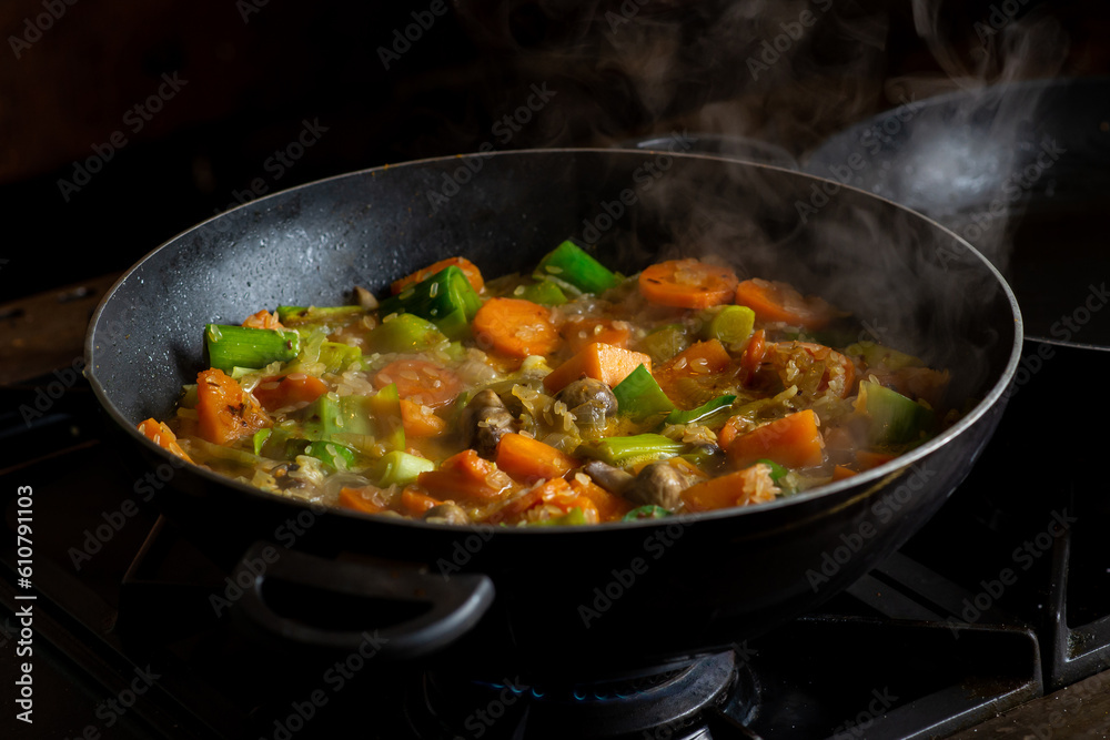 Cooking vegan vegetable stew. Rice with different vegetables - leek, mushrooms, potatoes seasoned with curry seasoning.