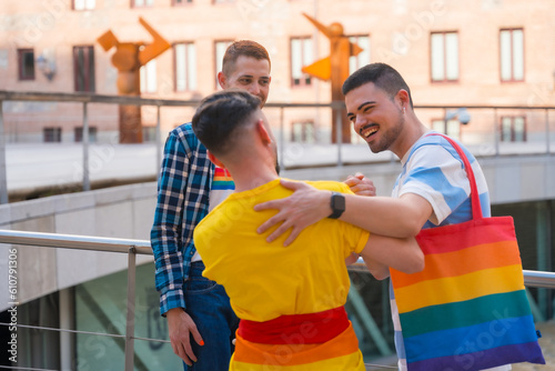 Friends waving and hugging at the demonstration with the rainbow flags, gay pride party in the city, lgbt concept