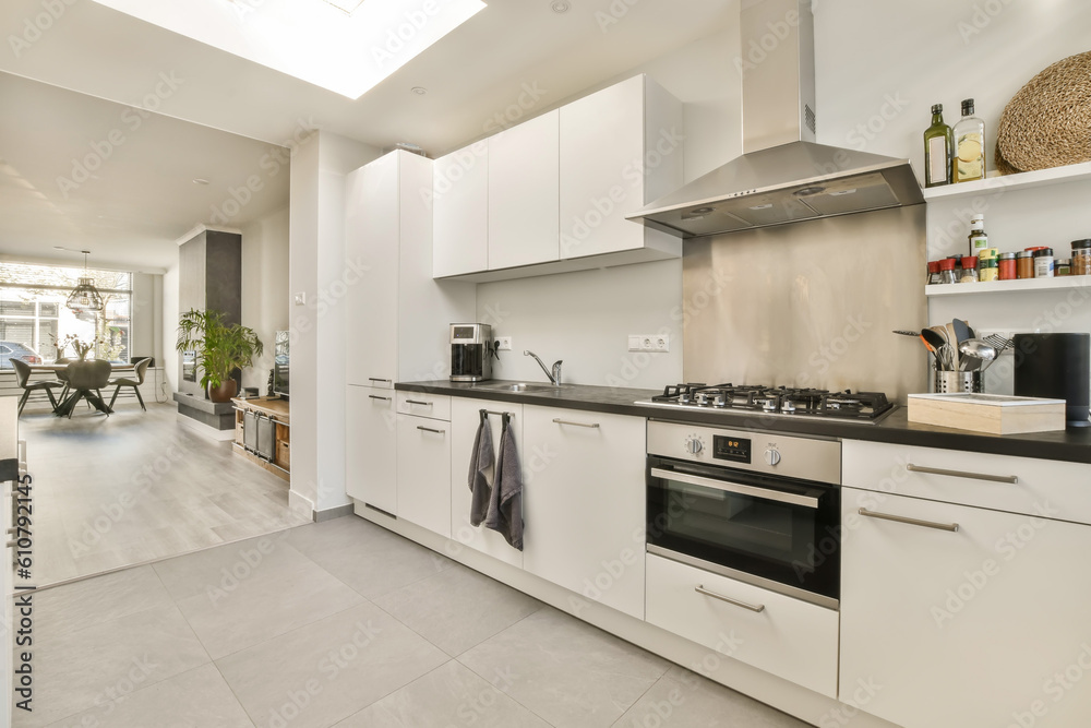 a kitchen with white cabinets and black counter tops on the counters in front of the oven, sink and dishwasher a kitchen with white cabinets and black counter tops on the counters in front of the oven, sink and dishwasher