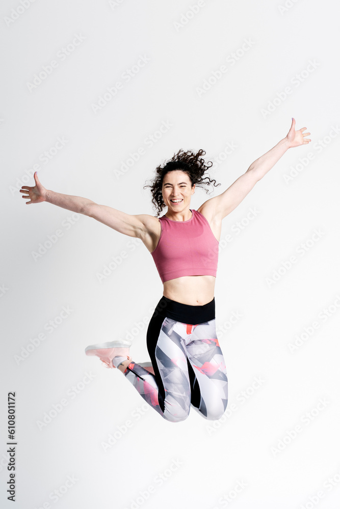 Athlete woman, jumping high up, exercising, expressing positive emotions isolated