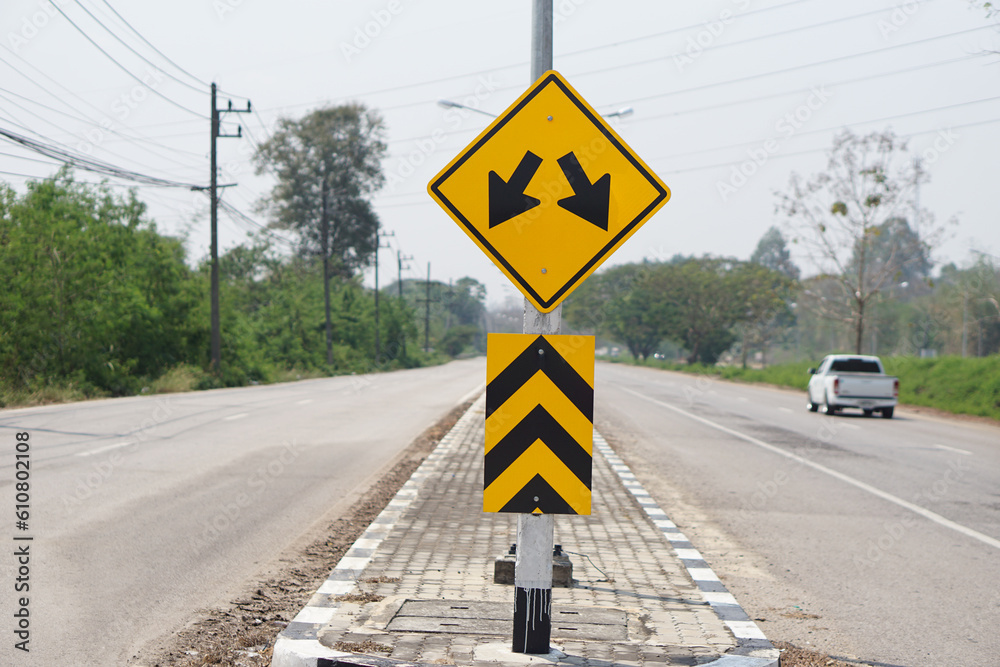 Yellow warning road sign with symbol of arrows on the road for the two way run in rural of Thailand. Yellow warning road sign with symbol of arrows on the road for the two way run in rural of Thailand.