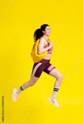 Active competitive determined sportswoman jumping high, jogging marathon