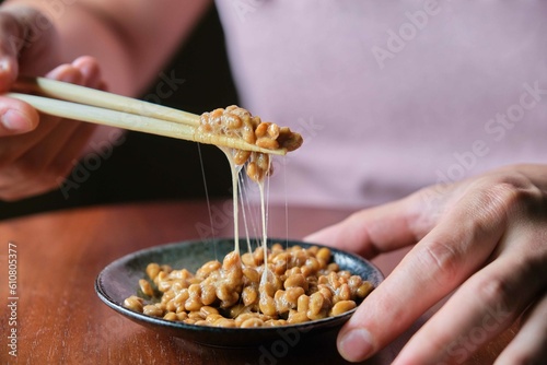 Obraz na płótnie Unrecognizable man eating natto fermented soy beans with chopsticks. w salonie