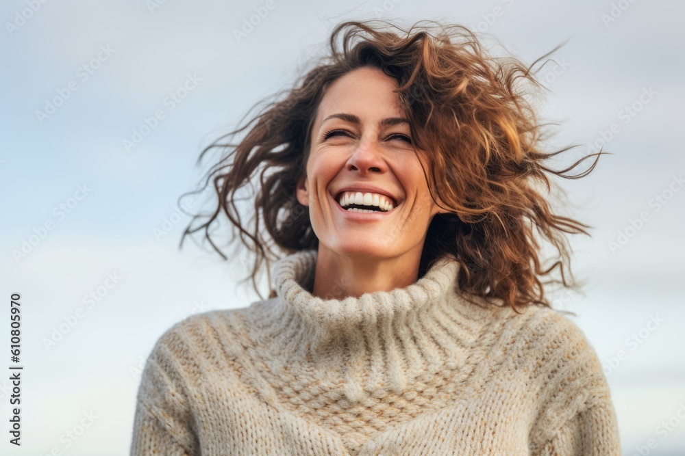 Close-up portrait photography of a grinning woman in her 40s that is wearing a cozy sweater against a sky and clouds background .  Generative AI