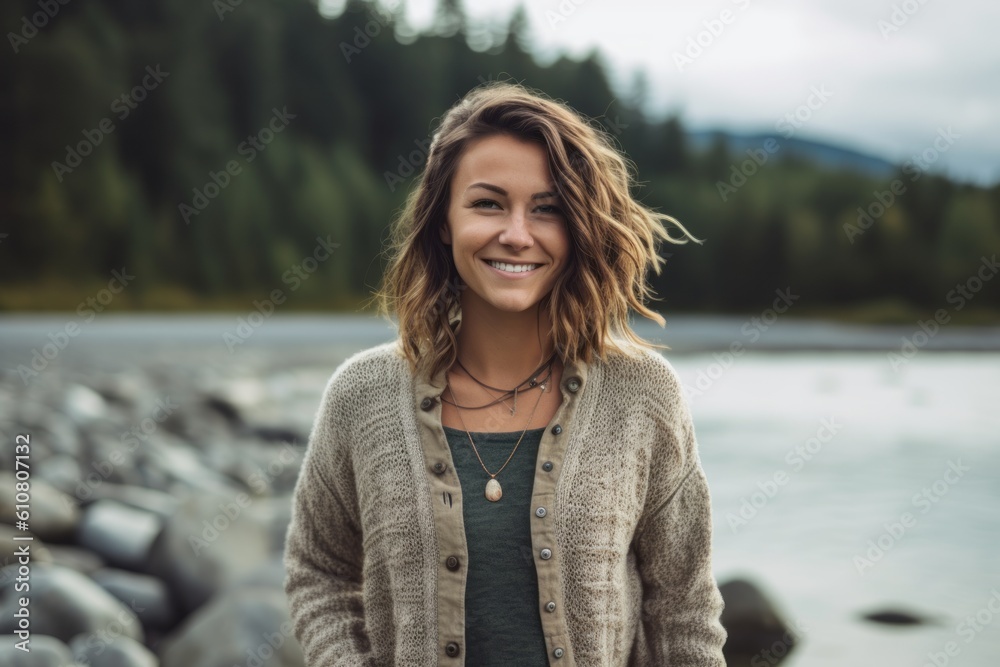 Portrait of a beautiful young woman smiling at the camera while standing by a lake Portrait of a beautiful young woman smiling at the camera while standing by a lake