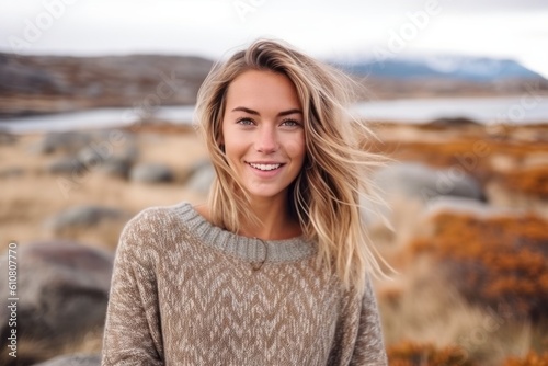 Beautiful young woman with blonde hair in a knitted sweater in Iceland