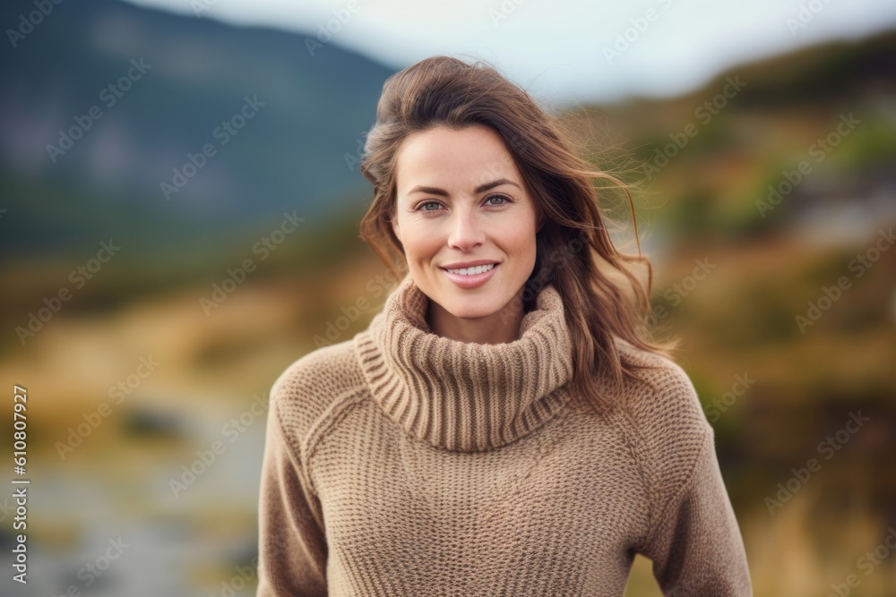 Portrait of a smiling young woman in sweater standing outdoors in autumn Portrait of a smiling young woman in sweater standing outdoors in autumn